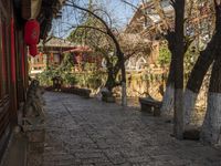 a street with stone steps, old buildings and a stone bench under an overhang