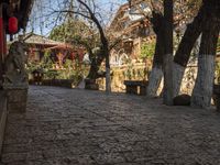 a street with stone steps, old buildings and a stone bench under an overhang