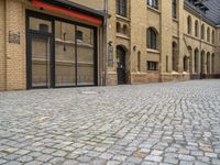 an outside city scene showing cobblestone and buildings with red trims that match