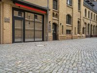 an outside city scene showing cobblestone and buildings with red trims that match