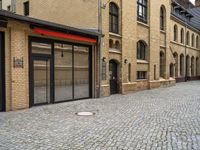 an outside city scene showing cobblestone and buildings with red trims that match