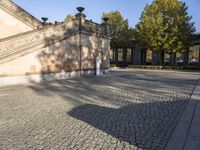 an image of a bench under some lights in the shade in a city courtyard area