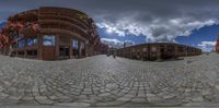 a panorama of a cobblestone street and buildings as seen from the side of the street