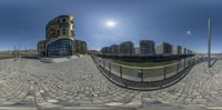 an image of a fish eye view of buildings and water from the sidewalk with a ramp