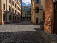 a sidewalk with chairs next to the brick building on the side, some have stairs and some buildings in the background