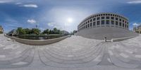 the circular photo is being taken by someone walking in front of some buildings on a cobblestone walkway