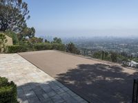 a house and a walkway with a view on cityscape in the distance with trees