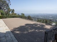 a house and a walkway with a view on cityscape in the distance with trees