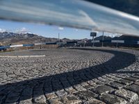 a cobblestone walkway leads to a parking space for the skiers to go skiing