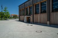 circles in the middle of the cement floor outside an empty building with a wooden facade