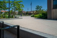 a person riding a skate board on the cement surface in front of a building and trees