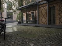 two bikes parked next to each other near a building on a cobblestone street