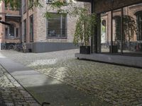 two bikes parked next to each other near a building on a cobblestone street