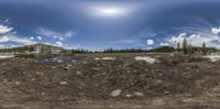 a very high alpine scenery with a road and mountains on one side and a stream in the other