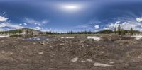 a very high alpine scenery with a road and mountains on one side and a stream in the other