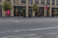 a man rides a bike on an empty street in front of a building with many windows