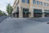 a street with a store and cars parked along it, and the sidewalk that is empty