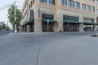 a street with a store and cars parked along it, and the sidewalk that is empty