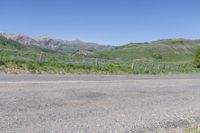 a yellow fire hydrant in the middle of a dirt road with mountains in the background