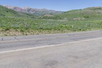 a yellow fire hydrant in the middle of a dirt road with mountains in the background