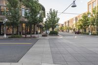 a street with buildings along it and a bench on the sidewalk near the side walk