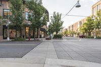 a street with buildings along it and a bench on the sidewalk near the side walk