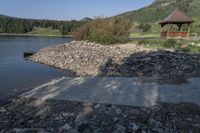 stone, concrete and wood pathway leading out onto the water and pavilion near the shore