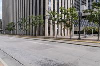 a yellow stop sign on a city sidewalk in front of tall buildings and trees in the middle of a street