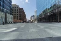 a street in a city with high rise buildings, and lots of concrete and concrete flooring