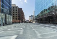 a street in a city with high rise buildings, and lots of concrete and concrete flooring