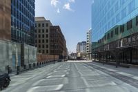 a street in a city with high rise buildings, and lots of concrete and concrete flooring