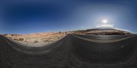 a picture taken through an open tunnel looking into the desert and beyond it is a sky with clouds