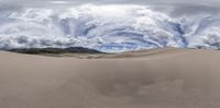 large sand dune with a beautiful sky in the background and clouds in the foreground