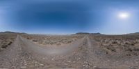 a fish eye view looking back at the desert landscape with dirt paths in front of it