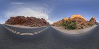 a curved road in the middle of a desert area with red rocks in the background