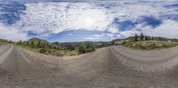 the panorama shot shows a dirt bike on the road at the top of the hill