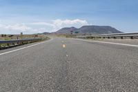 this is the empty highway near some mountains and a mountain range in the distance with an overhead view