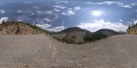 an image of a motorcycle on a road next to mountains in the distance from the view point perspective mirror