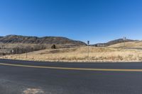 the corner of an empty road near a hill with a sky background in autumntime