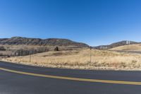 the corner of an empty road near a hill with a sky background in autumntime