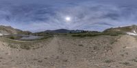 a reflection of the moon in a fisheye lens view of mountains and lakes below