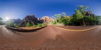 a curved road is seen in a fish eye lens with the sun shining on it