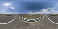 a fisheye view of an empty street and mountains in the background to the left