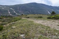 the trail is very dry and empty for people to ride on there are many mountains in the background