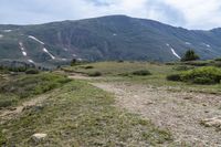 the trail is very dry and empty for people to ride on there are many mountains in the background