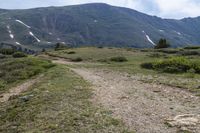 the trail is very dry and empty for people to ride on there are many mountains in the background