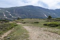 the trail is very dry and empty for people to ride on there are many mountains in the background