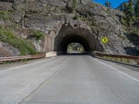 a road goes into a tunnel and through the hill to the other side of it