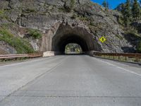 a road goes into a tunnel and through the hill to the other side of it