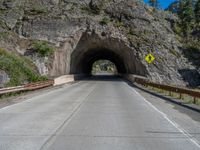 a road goes into a tunnel and through the hill to the other side of it